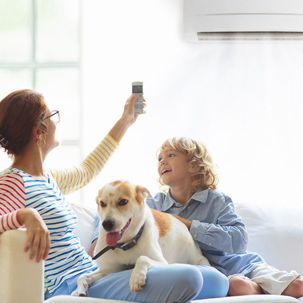 Mother and child with air conditioner remote