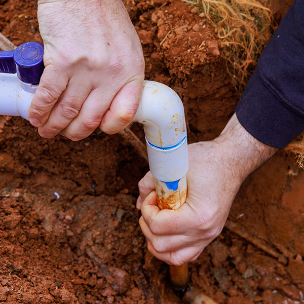 Worker connecting water to well system pumping water to house
