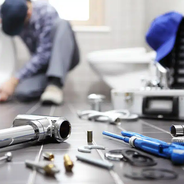 Plumber fixing pipes in bathroom