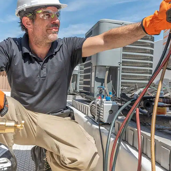 Technician checking HVAC unit in roof